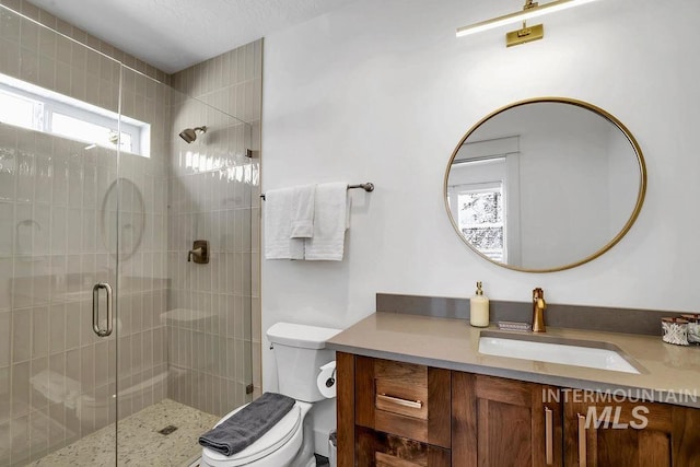 bathroom featuring vanity, toilet, and walk in shower