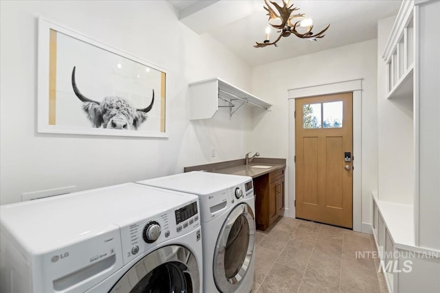 laundry area with cabinets, sink, a notable chandelier, and washing machine and clothes dryer