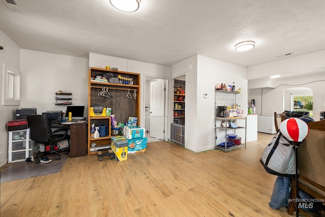 office area featuring visible vents, wood finished floors, and a textured ceiling