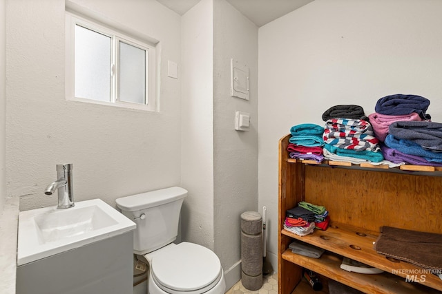 half bathroom featuring toilet and vanity