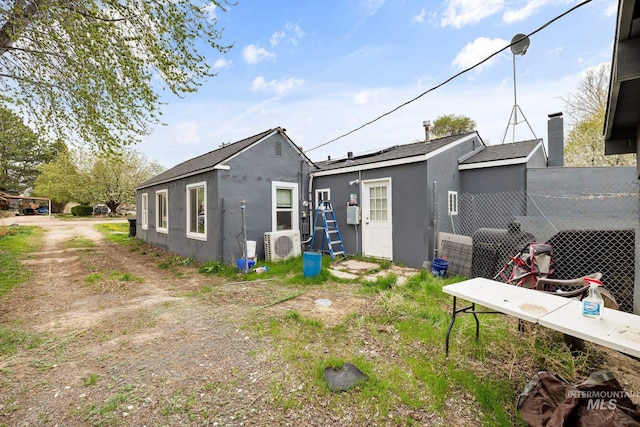 rear view of property featuring stucco siding and ac unit