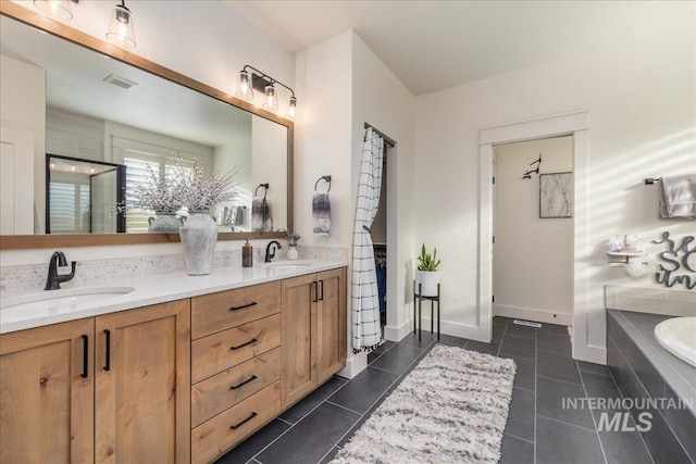 bathroom with vanity, tiled tub, and tile patterned flooring