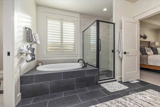 bathroom featuring tile patterned floors, toilet, and shower with separate bathtub