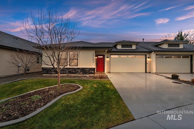 prairie-style home featuring a lawn and a garage