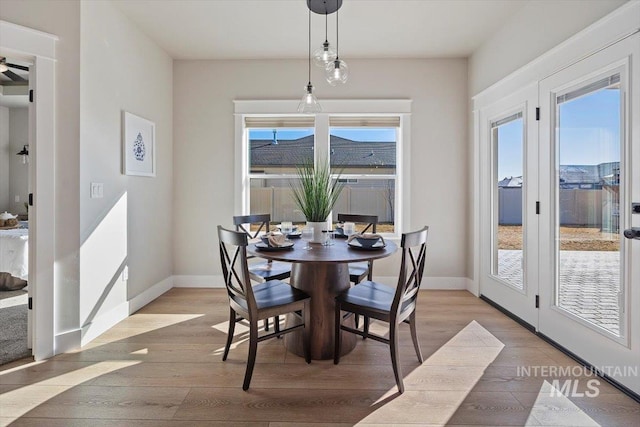 dining area featuring light wood-style flooring and baseboards