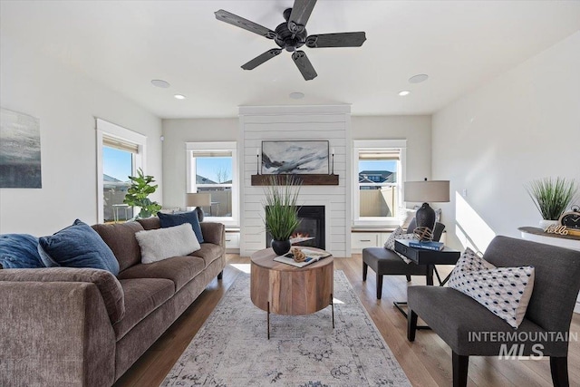 living room featuring recessed lighting, a large fireplace, ceiling fan, and wood finished floors