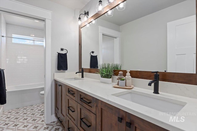 full bathroom with toilet, shower / tub combination, double vanity, and a sink