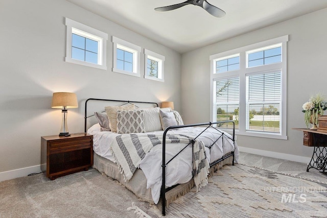 carpeted bedroom with ceiling fan and multiple windows