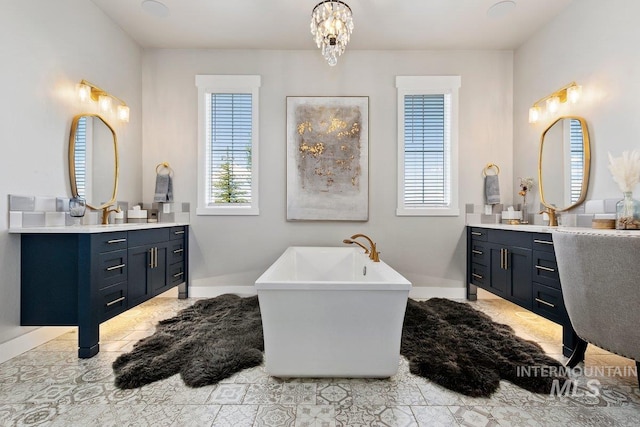 bathroom featuring a bathing tub, vanity, and a notable chandelier