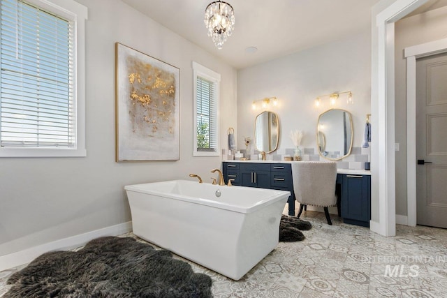 bathroom with vanity, a tub, and an inviting chandelier