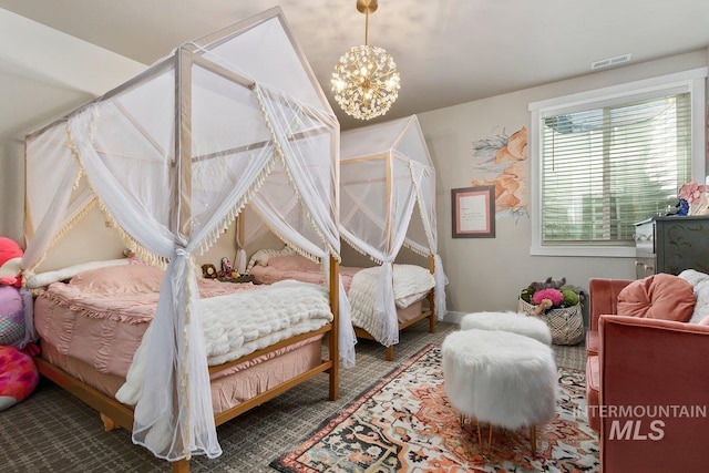 carpeted bedroom with an inviting chandelier