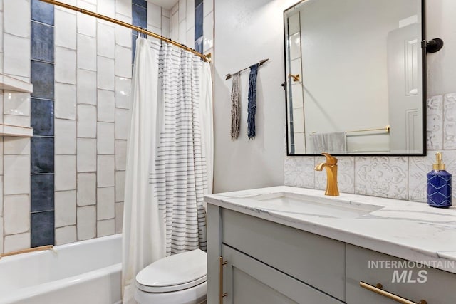 full bathroom with vanity, shower / tub combo, backsplash, and toilet