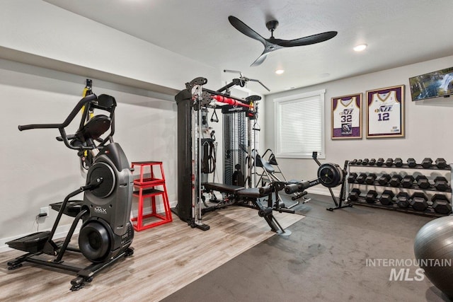 exercise room with ceiling fan and wood-type flooring