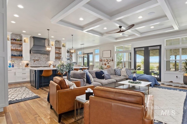 living room with french doors, coffered ceiling, ceiling fan, beam ceiling, and light hardwood / wood-style floors