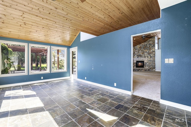 70 Pelican Dr, Rupert, ID 83350 - empty room with a ceiling fan, vaulted ceiling, wood ceiling, baseboards, and a stone fireplace