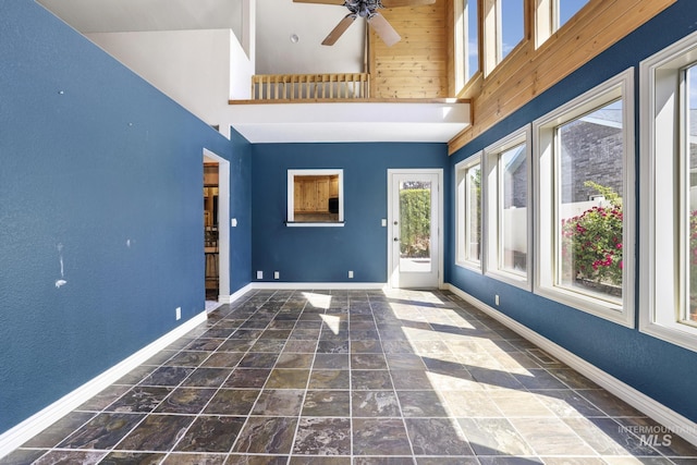 70 Pelican Dr, Rupert, ID 83350 - interior space with a ceiling fan, baseboards, stone finish flooring, and a towering ceiling