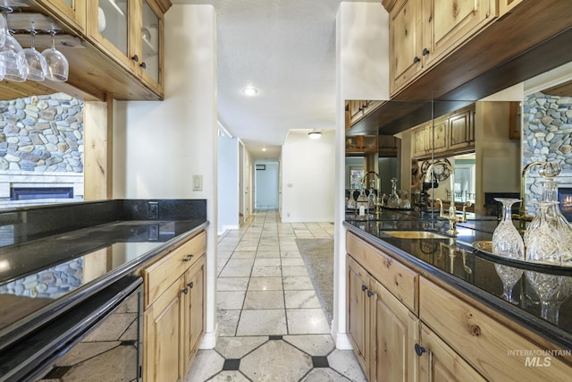 70 Pelican Dr, Rupert, ID 83350 - kitchen featuring a fireplace, stone tile floors, wine cooler, recessed lighting, and dark stone counters