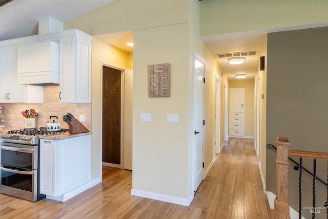 1205 Ponderosa Dr, Moscow, ID 83843 - kitchen featuring double oven range, light wood-style flooring, white cabinets, and custom exhaust hood