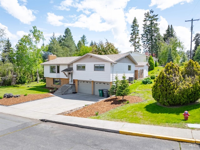 1205 Ponderosa Dr, Moscow, ID 83843 - raised ranch featuring an attached garage, driveway, a front yard, a chimney, and board and batten siding