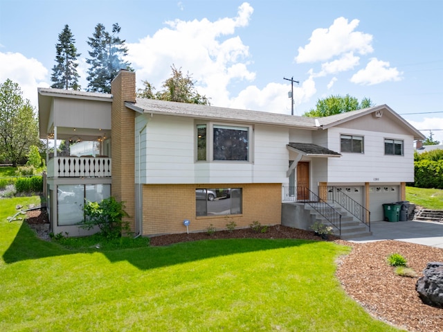 1205 Ponderosa Dr, Moscow, ID 83843 - bi-level home with driveway, an attached garage, a chimney, brick siding, and a front lawn