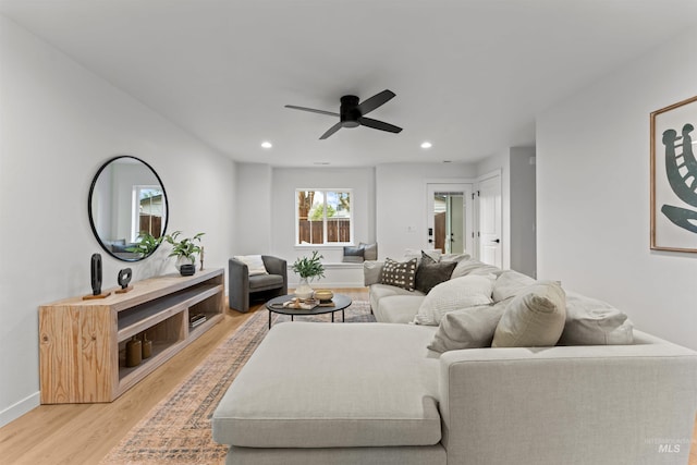 living room with ceiling fan and light hardwood / wood-style flooring