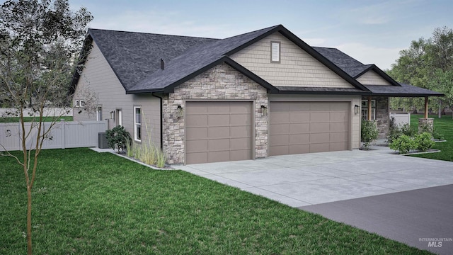 view of front of property with a garage, a front yard, and central AC