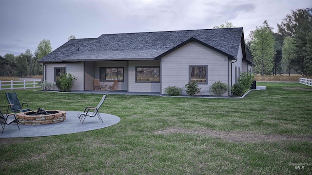 rear view of property featuring a yard, a fire pit, and a patio area