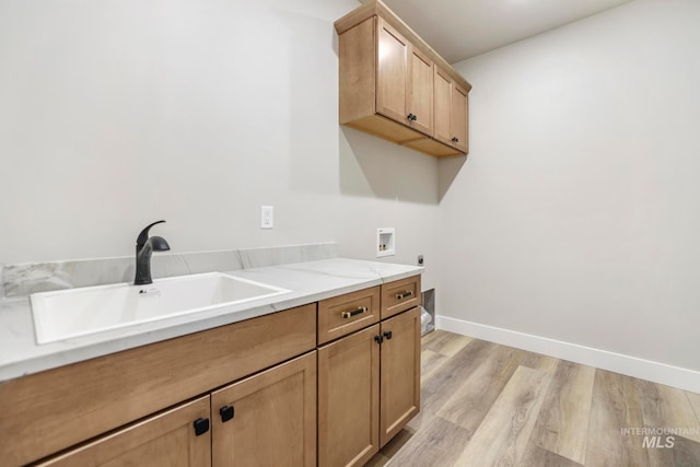 washroom featuring electric dryer hookup, cabinets, sink, hookup for a washing machine, and light hardwood / wood-style floors