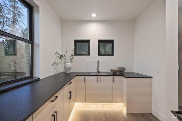 bar featuring a sink, light wood-style flooring, and recessed lighting