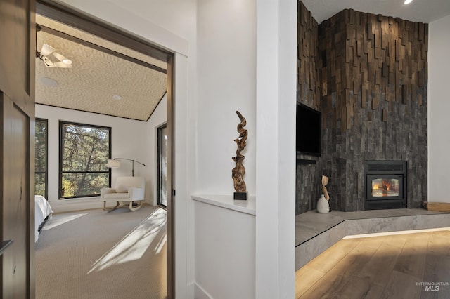carpeted living area with a textured ceiling, a glass covered fireplace, and lofted ceiling