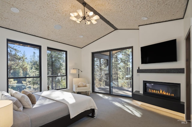 carpeted bedroom with an inviting chandelier, a textured ceiling, a glass covered fireplace, vaulted ceiling, and access to exterior