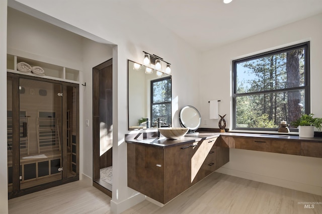full bath featuring walk in shower, vanity, and wood finished floors