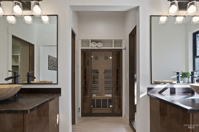 bathroom with a sink, a chandelier, and wood finished floors