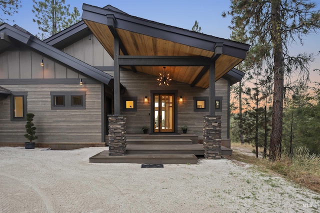 exterior entry at dusk featuring french doors and board and batten siding