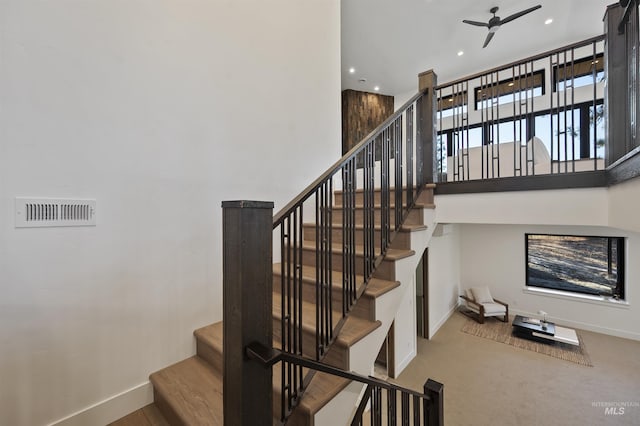 staircase with ceiling fan, a towering ceiling, visible vents, recessed lighting, and baseboards