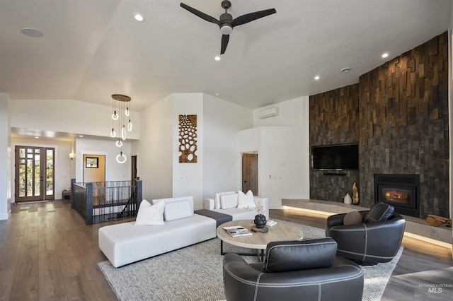 living area featuring a fireplace, a ceiling fan, vaulted ceiling, recessed lighting, and wood finished floors