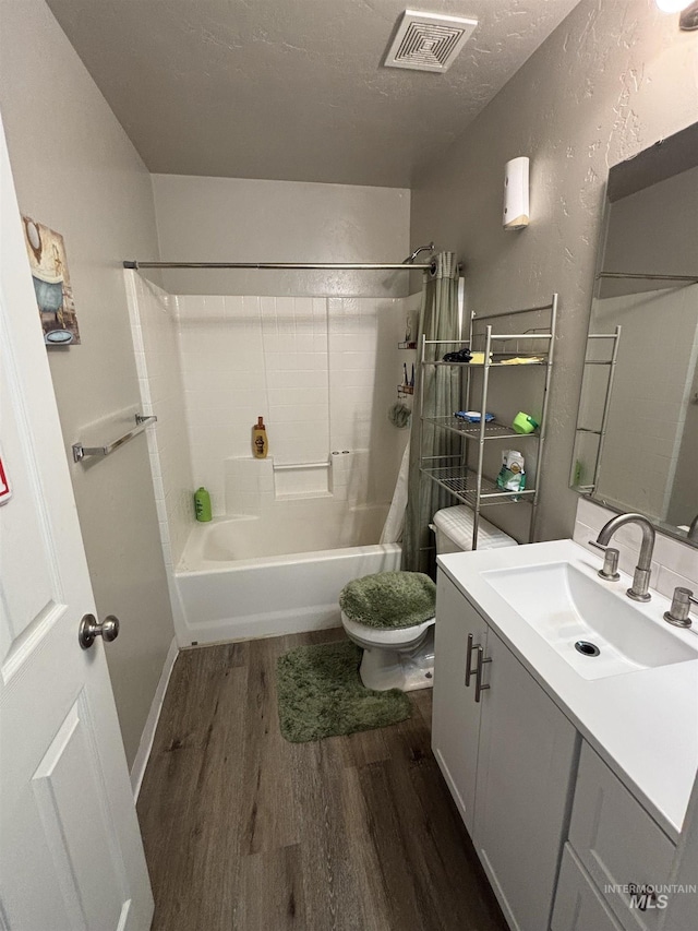 4618 Braeburn, Caldwell, ID 83607 - full bathroom featuring vanity, visible vents, toilet, wood finished floors, and a textured wall
