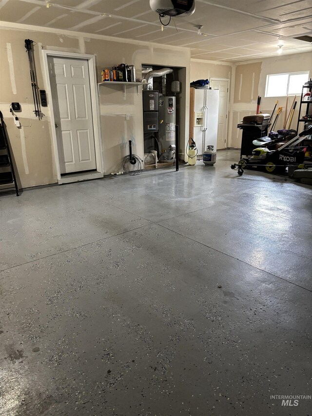 4618 Braeburn, Caldwell, ID 83607 - garage featuring white refrigerator with ice dispenser, gas water heater, and a garage door opener