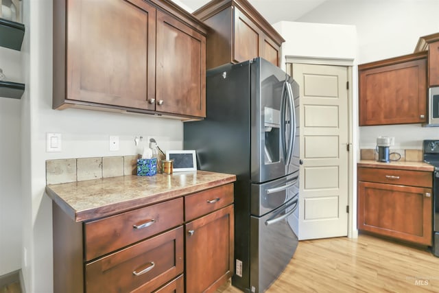 kitchen featuring light countertops, light wood-style flooring, and appliances with stainless steel finishes