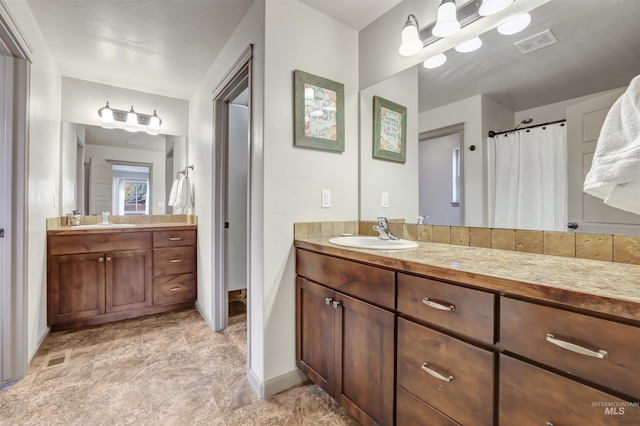 bathroom with visible vents, baseboards, and vanity