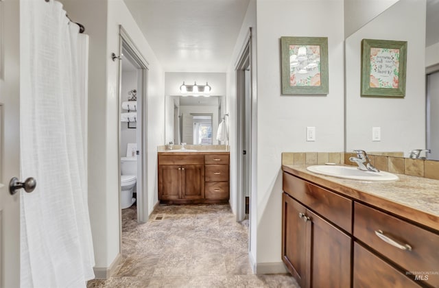 full bathroom with toilet and vanity