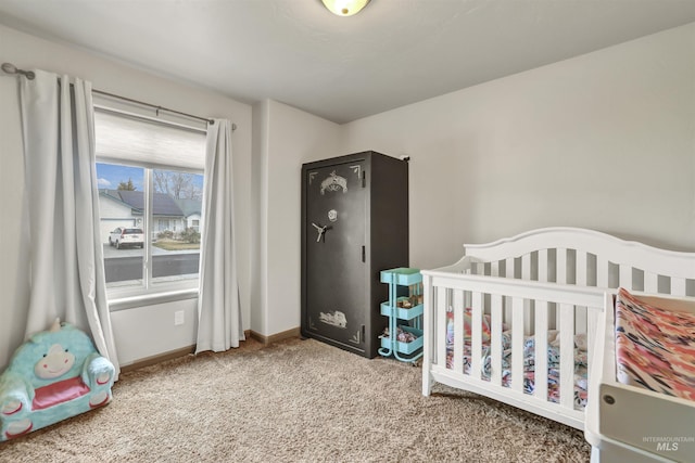 carpeted bedroom featuring baseboards and a nursery area