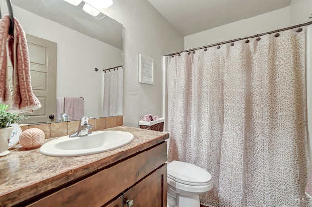 full bathroom featuring vanity, toilet, and a textured wall