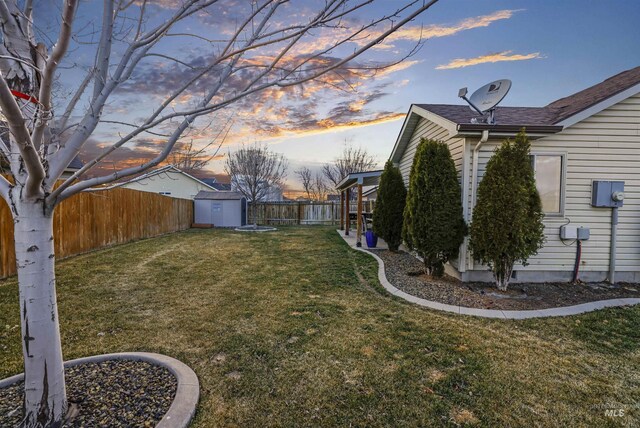 view of yard featuring a storage unit, a fenced backyard, and an outdoor structure