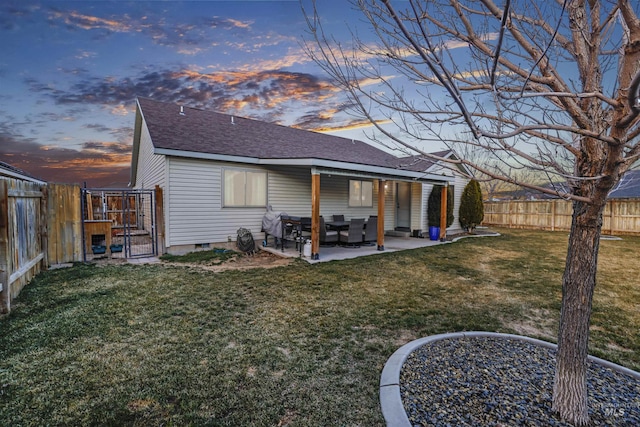 back of house featuring a yard, roof with shingles, a fenced backyard, and a patio area