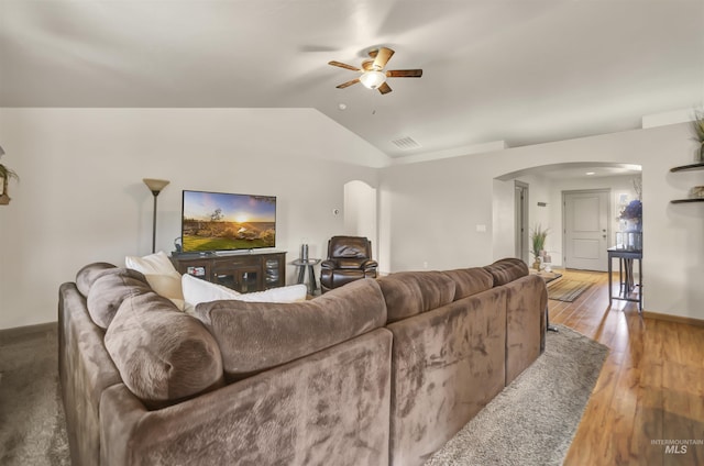 living room featuring hardwood / wood-style floors, visible vents, arched walkways, ceiling fan, and vaulted ceiling