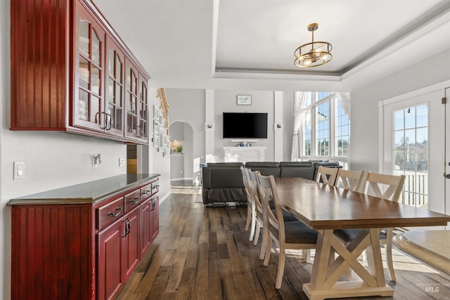 dining area featuring a chandelier, dark hardwood / wood-style floors, and a tray ceiling