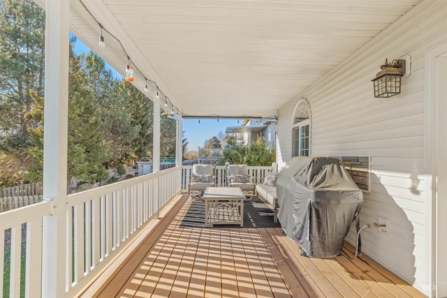 wooden deck with outdoor lounge area and area for grilling