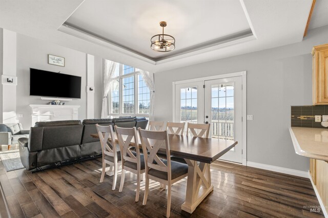 dining room with french doors, a chandelier, dark hardwood / wood-style floors, and a tray ceiling