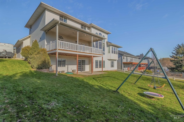 back of house featuring a playground and a lawn